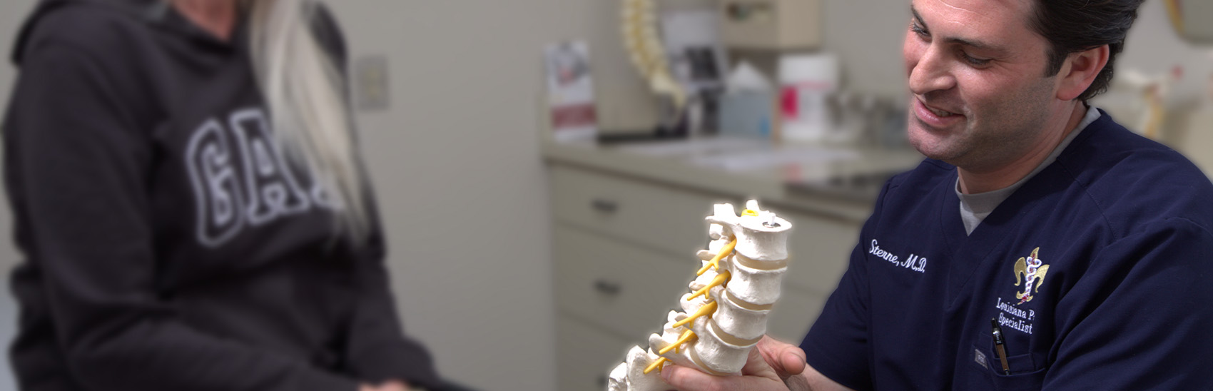Dr. Eric Sterne showing spine mold to patient.