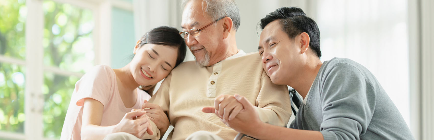 A grandfather with his two grandchildren, happy to have a prolonged life due to pain management.