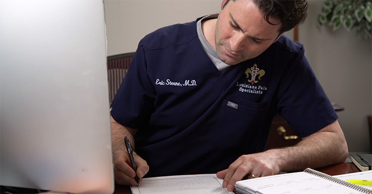 Dr. Eric Sterne filling out some paperwork at his desk.