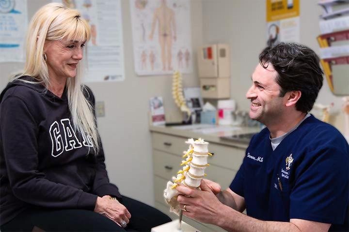 A doctor with Louisiana Pain Specialist showing a patient what the spine looks like.