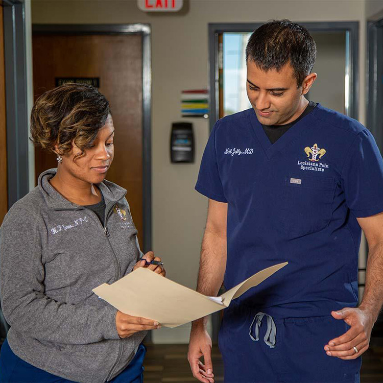 A doctor with a staff member, looking over insurance forms.